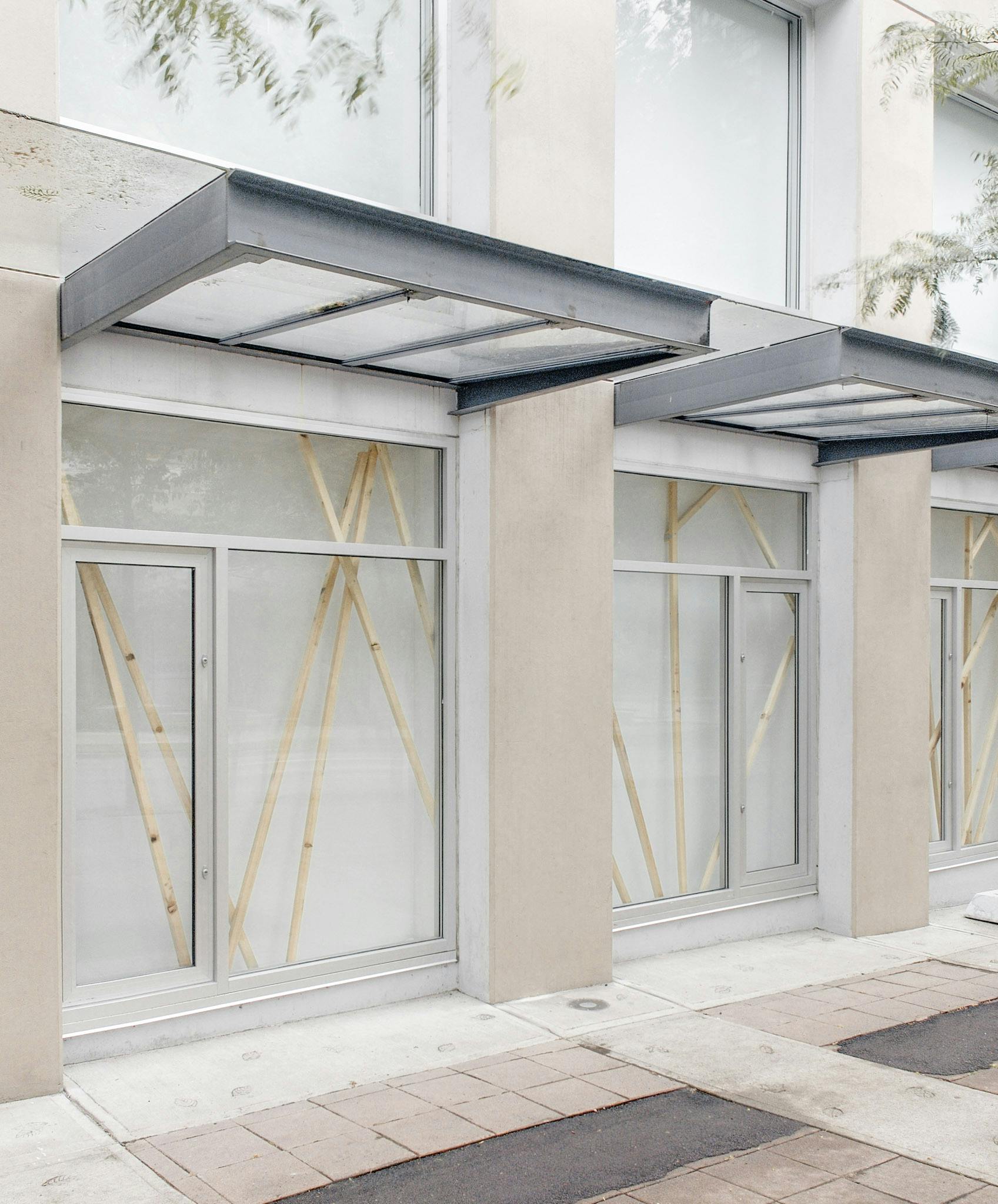 This image shows three of CAG’s window spaces, in which Elspeth Pratt’s installation art is displayed. Unpained thin wooden bars are diagonally installed in those window spaces.