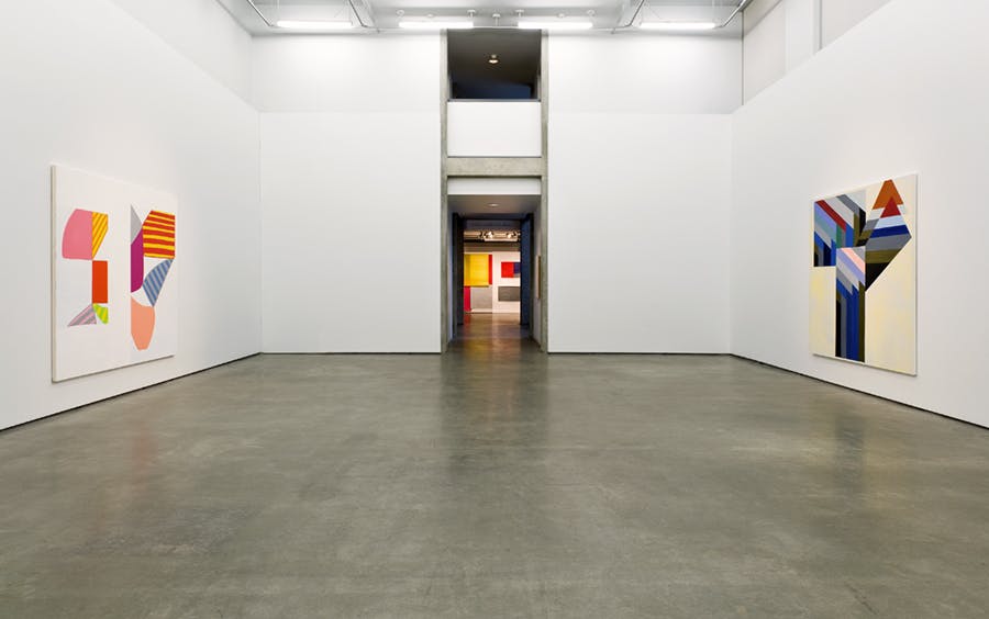 Installation image of Elizabeth McIntosh's exhibition. Two large-scale artworks mounted on parallel walls. At the center is a hallway connecting gallery spaces with a distant view of more works.