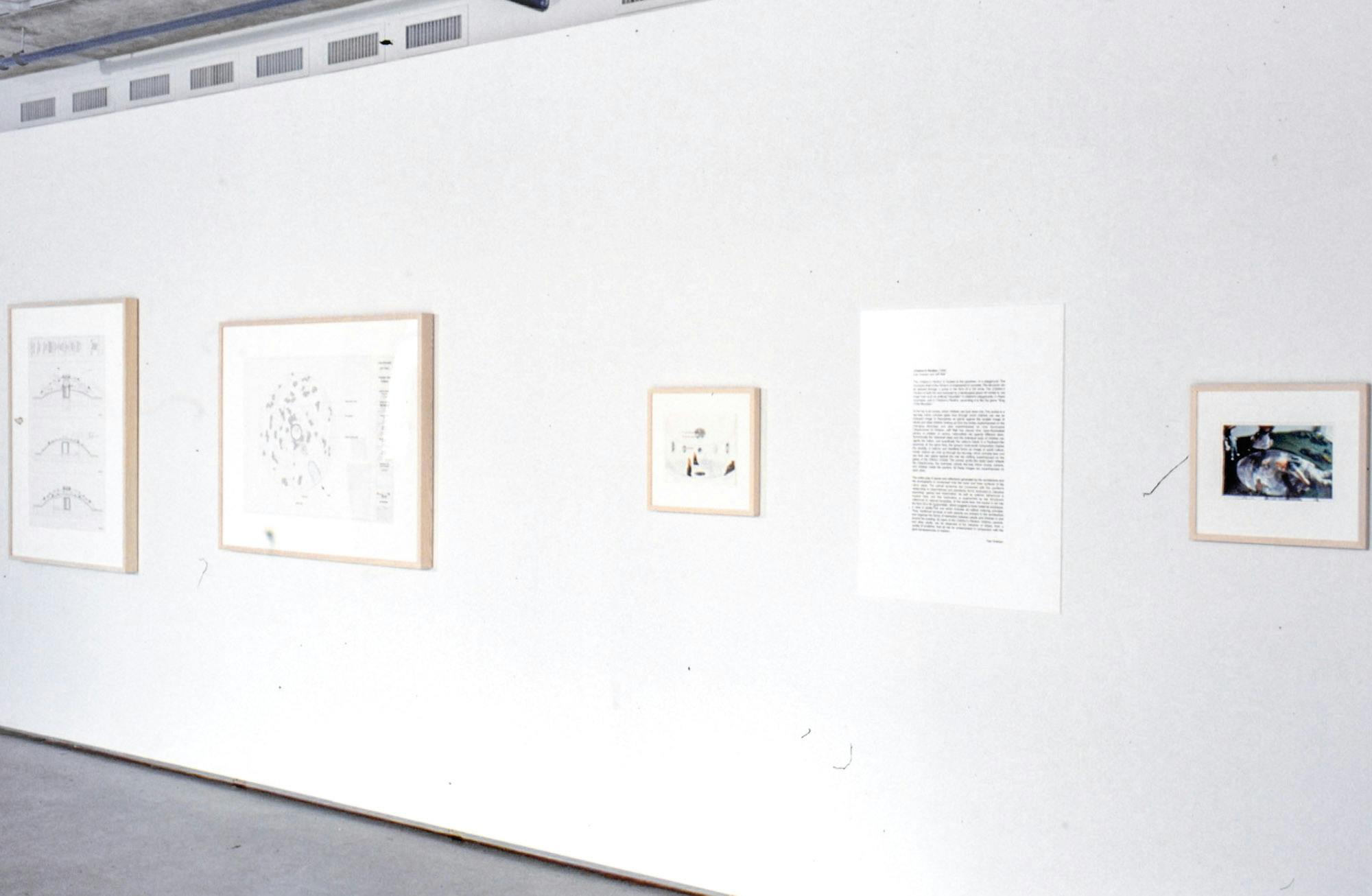Five artworks are installed on a gallery wall. A text-based work is placed in between a coloured photograph and a drawing. Two large black and white drawings are mounted in the back. 