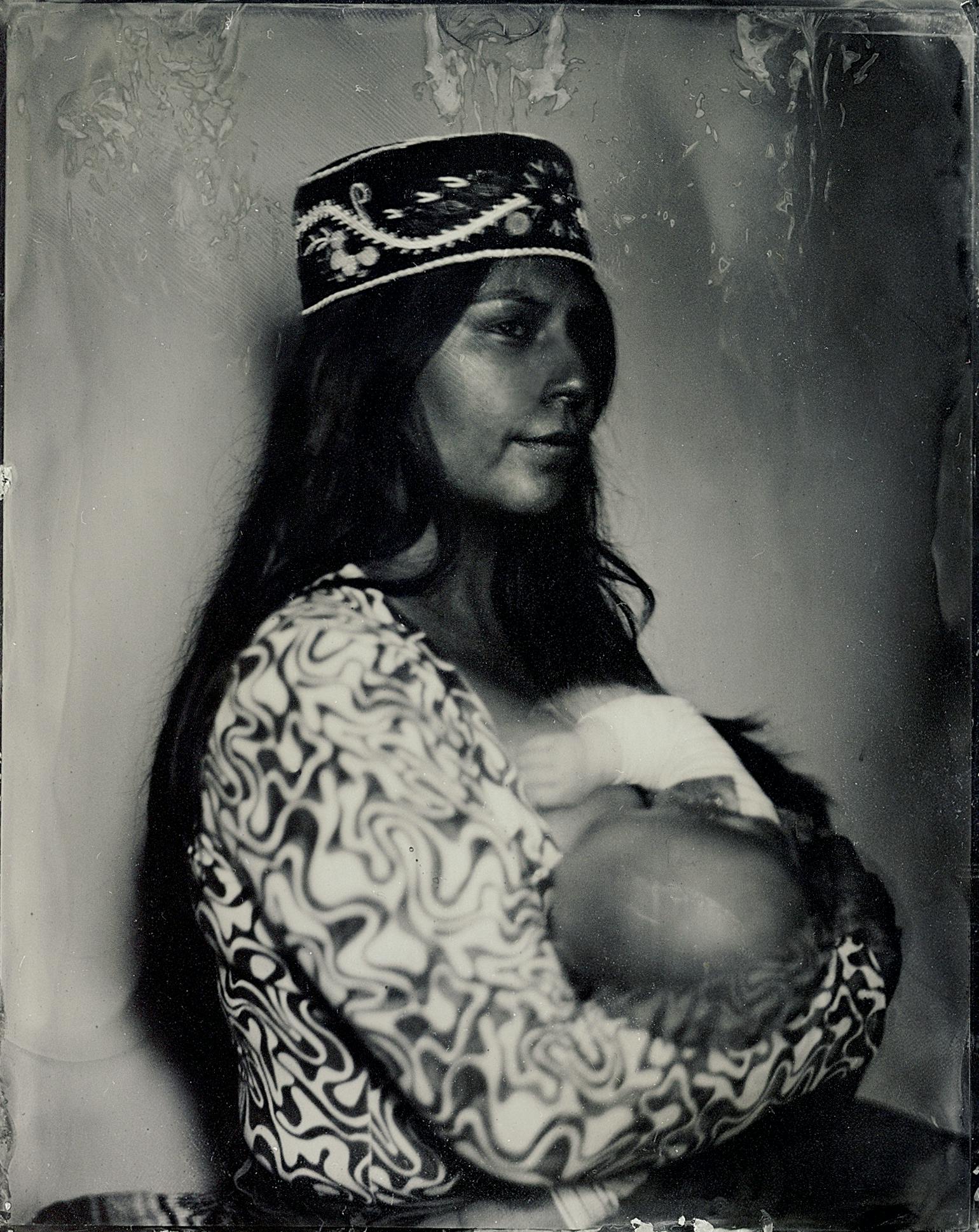 A tintype image of Audie Murray in profile. She is holding a baby in her arms.